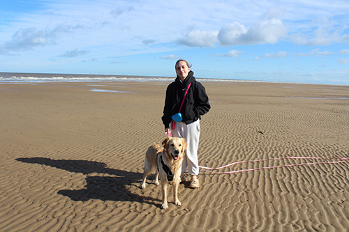 Photo of Toni walking Buffy on the beach